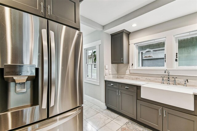 711 S Bungalow Ter, Tampa, FL 33606 - kitchen with stainless steel fridge, light marble finish flooring, recessed lighting, and gray cabinetry