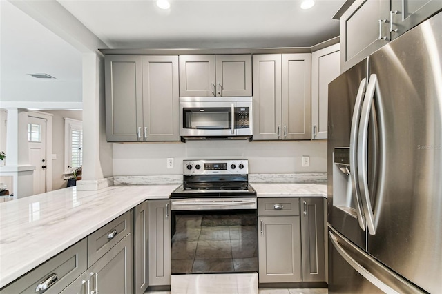 711 S Bungalow Ter, Tampa, FL 33606 - kitchen with appliances with stainless steel finishes, gray cabinets, light stone countertops, and recessed lighting