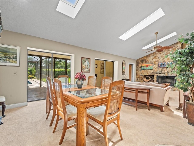 4209 Winding Willow Dr, Tampa, FL 33618 - dining room featuring a skylight, light colored carpet, ceiling fan, a stone fireplace, and lofted ceiling