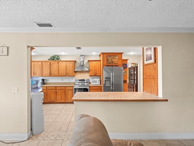 4209 Winding Willow Dr, Tampa, FL 33618 - kitchen featuring stainless steel appliances, wall chimney range hood, a textured ceiling, light tile patterned flooring, and crown molding