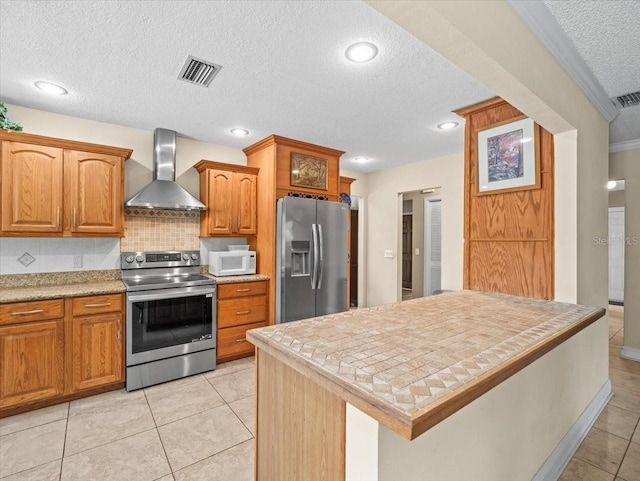 4209 Winding Willow Dr, Tampa, FL 33618 - kitchen with appliances with stainless steel finishes, wall chimney range hood, a textured ceiling, tasteful backsplash, and light tile patterned flooring