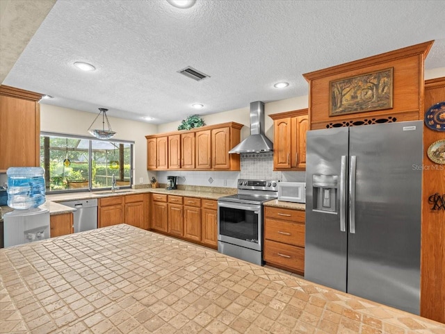 4209 Winding Willow Dr, Tampa, FL 33618 - kitchen with appliances with stainless steel finishes, wall chimney range hood, light countertops, a textured ceiling, and decorative backsplash