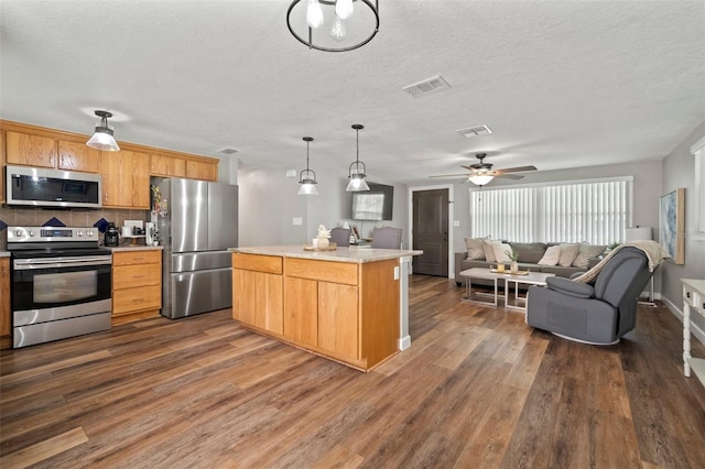 903 Dixie Maid Ln, Valrico, FL 33594 - kitchen with stainless steel appliances, dark wood-type flooring, tasteful backsplash, a ceiling fan, and a textured ceiling