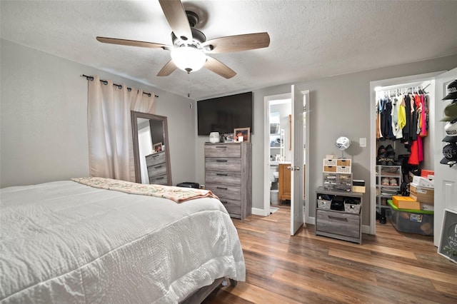 903 Dixie Maid Ln, Valrico, FL 33594 - bedroom with a textured ceiling, a spacious closet, wood finished floors, a closet, and a ceiling fan