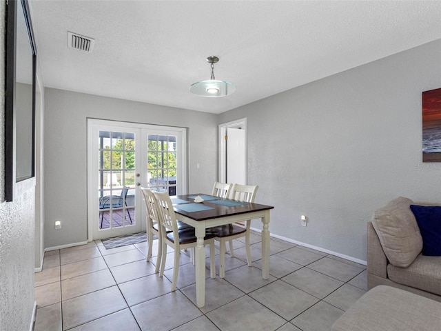 9109 134th Way, Seminole, FL 33776 - dining room with french doors, light tile patterned floors, a textured ceiling, and a textured wall