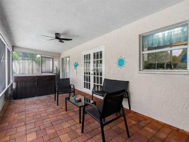 9109 134th Way, Seminole, FL 33776 - sunroom with a jacuzzi, french doors, a textured wall, a textured ceiling, and brick patterned flooring