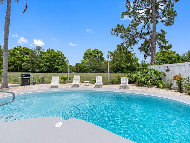 9109 134th Way, Seminole, FL 33776 - view of swimming pool featuring a fenced backyard, a grill, and view of wooded area
