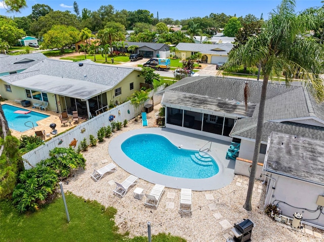 9109 134th Way, Seminole, FL 33776 - view of swimming pool featuring a sunroom, a fenced backyard, a patio, and a residential view