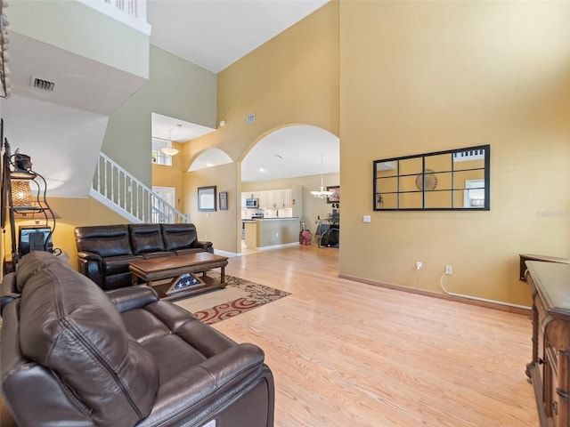 8222 Haven Harbour Way, Bradenton, FL 34212 - living room featuring a towering ceiling, wood finished floors, arched walkways, and stairs
