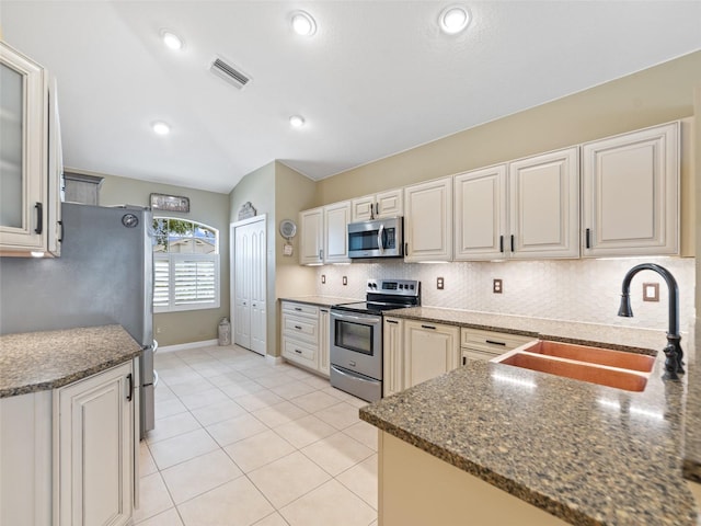 8222 Haven Harbour Way, Bradenton, FL 34212 - kitchen with stainless steel appliances, decorative backsplash, dark stone countertops, light tile patterned flooring, and recessed lighting