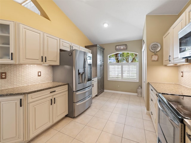 8222 Haven Harbour Way, Bradenton, FL 34212 - kitchen with appliances with stainless steel finishes, cream cabinetry, backsplash, vaulted ceiling, and light tile patterned floors