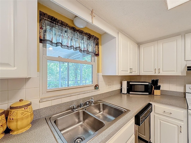 1102 Cara Dr, Largo, FL 33771 - kitchen with dishwashing machine, white cabinets, backsplash, range, and a textured ceiling