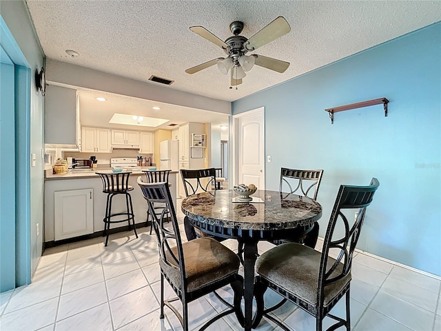 1102 Cara Dr, Largo, FL 33771 - dining space featuring ceiling fan, light tile patterned floors, and a textured ceiling