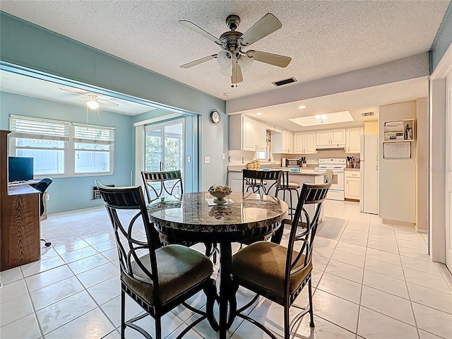1102 Cara Dr, Largo, FL 33771 - dining area featuring ceiling fan, light tile patterned floors, and a textured ceiling