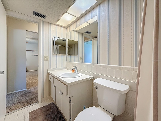 1102 Cara Dr, Largo, FL 33771 - bathroom featuring wallpapered walls, vanity, a textured ceiling, and tile patterned flooring