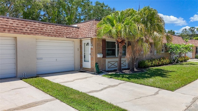 1102 Cara Dr, Largo, FL 33771 - view of front facade featuring roof with shingles, mansard roof, concrete driveway, a front yard, and an attached garage