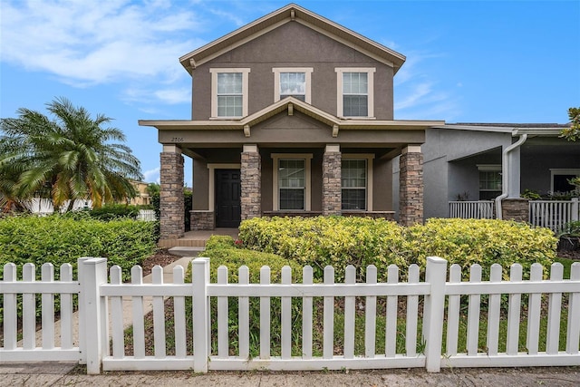 2706 Lantern Hill Ave, Brandon, FL 33511 - view of front facade featuring stucco siding, stone siding, a porch, and a fenced front yard