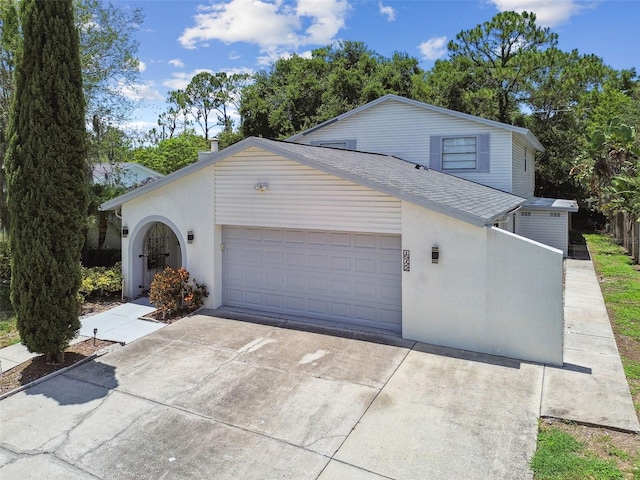 15722 Gardenside Ln, Tampa, FL 33624 - view of front of property featuring a garage, concrete driveway, stucco siding, and roof with shingles