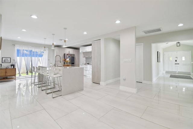 15722 Gardenside Ln, Tampa, FL 33624 - kitchen featuring smart refrigerator, a kitchen breakfast bar, a kitchen island with sink, recessed lighting, and light countertops