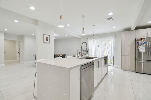 15722 Gardenside Ln, Tampa, FL 33624 - kitchen featuring stainless steel appliances, modern cabinets, light countertops, a kitchen island with sink, and recessed lighting