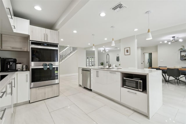 15722 Gardenside Ln, Tampa, FL 33624 - kitchen with appliances with stainless steel finishes, light countertops, pendant lighting, white cabinetry, and recessed lighting