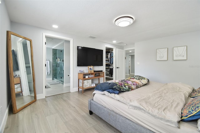 15722 Gardenside Ln, Tampa, FL 33624 - bedroom featuring light wood-style flooring, a spacious closet, recessed lighting, connected bathroom, and a closet