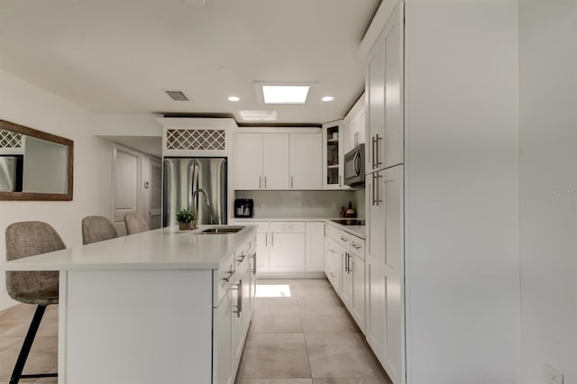 4727 Town N Country Blvd, Tampa, FL 33615 - kitchen with appliances with stainless steel finishes, a breakfast bar area, recessed lighting, light countertops, and glass insert cabinets
