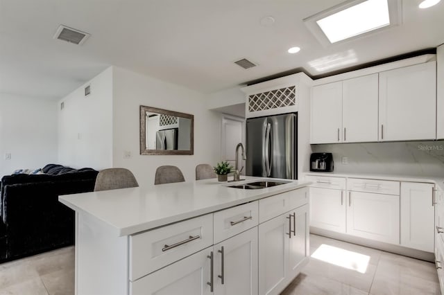 4727 Town N Country Blvd, Tampa, FL 33615 - kitchen featuring freestanding refrigerator, light countertops, a kitchen island with sink, recessed lighting, and white cabinets