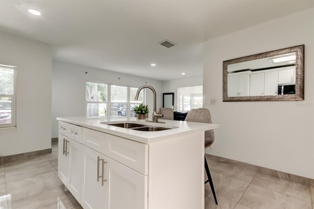 4727 Town N Country Blvd, Tampa, FL 33615 - kitchen featuring a kitchen bar, white cabinets, recessed lighting, light countertops, and light tile patterned floors