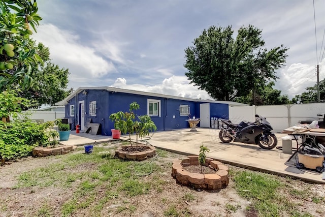 4727 Town N Country Blvd, Tampa, FL 33615 - rear view of property with a fenced backyard, a patio, and an outdoor fire pit