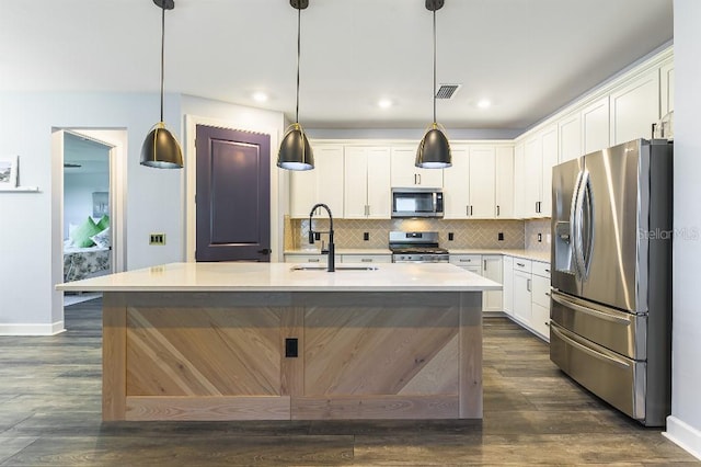 7683 Summerland Cv, Lakewood Ranch, FL 34202 - kitchen featuring appliances with stainless steel finishes, white cabinetry, light countertops, decorative backsplash, and recessed lighting