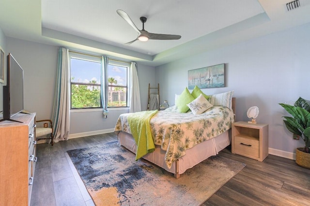 7683 Summerland Cv, Lakewood Ranch, FL 34202 - bedroom featuring a raised ceiling, dark wood-type flooring, and a ceiling fan