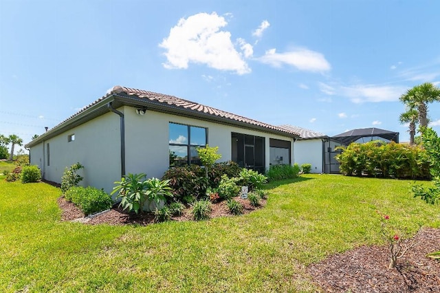 7683 Summerland Cv, Lakewood Ranch, FL 34202 - back of house featuring stucco siding, a lawn, and a tiled roof