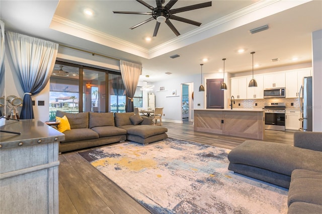 7683 Summerland Cv, Lakewood Ranch, FL 34202 - living area featuring ceiling fan, a raised ceiling, ornamental molding, dark wood-style flooring, and recessed lighting