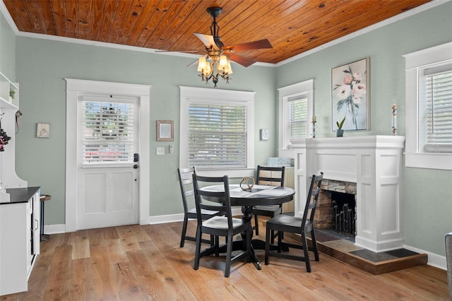 6016 N Dexter Ave, Tampa, FL 33604 - dining area featuring crown molding, ceiling fan, light wood-type flooring, a stone fireplace, and wooden ceiling