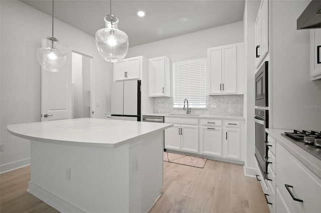 2511 N Grady Ave Unit 43, Tampa, FL 33607 - kitchen featuring stainless steel appliances, light wood-style flooring, decorative backsplash, a kitchen island, and recessed lighting