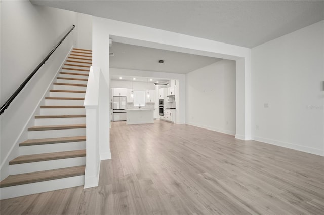 2511 N Grady Ave Unit 43, Tampa, FL 33607 - unfurnished living room with light wood-type flooring and stairs