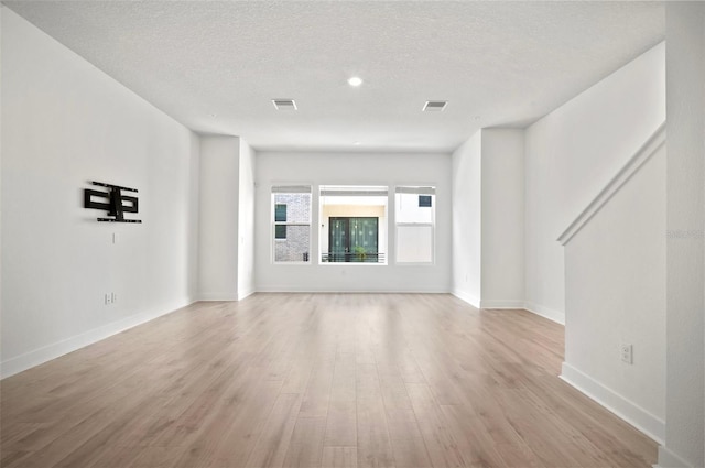 2511 N Grady Ave Unit 43, Tampa, FL 33607 - unfurnished living room with light wood-style flooring and a textured ceiling