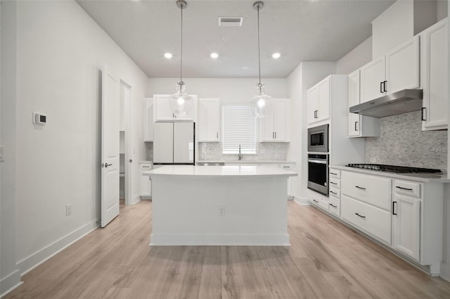2511 N Grady Ave Unit 43, Tampa, FL 33607 - kitchen with under cabinet range hood, appliances with stainless steel finishes, backsplash, white cabinets, and recessed lighting
