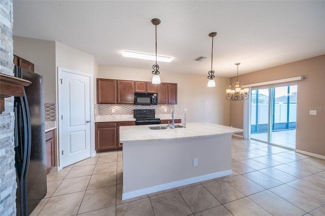 14524 Dunrobin Dr, Wimauma, FL 33598 - kitchen with black appliances, tasteful backsplash, light tile patterned floors, and decorative light fixtures