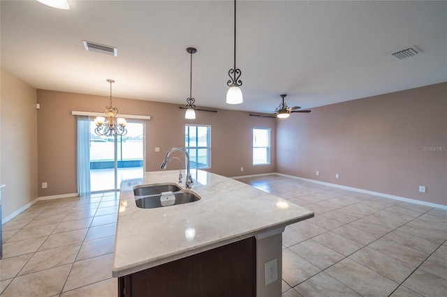 14524 Dunrobin Dr, Wimauma, FL 33598 - kitchen with light tile patterned flooring, hanging light fixtures, a ceiling fan, a chandelier, and light stone countertops