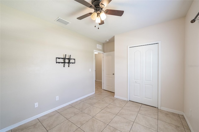 14524 Dunrobin Dr, Wimauma, FL 33598 - unfurnished bedroom with a closet, light tile patterned floors, and a ceiling fan