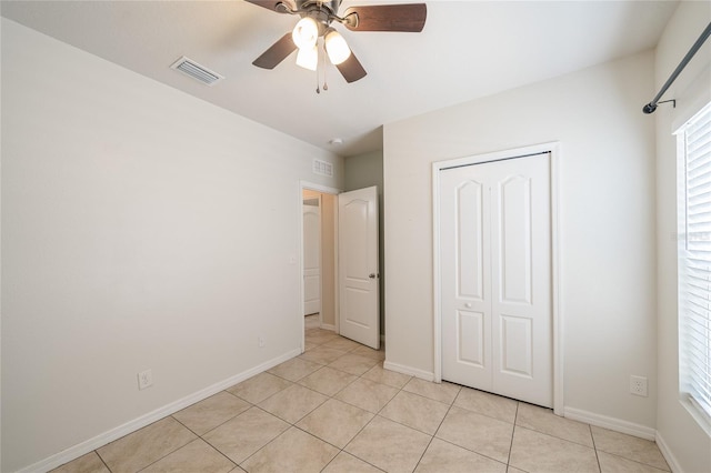 14524 Dunrobin Dr, Wimauma, FL 33598 - unfurnished bedroom with light tile patterned flooring, a closet, and a ceiling fan