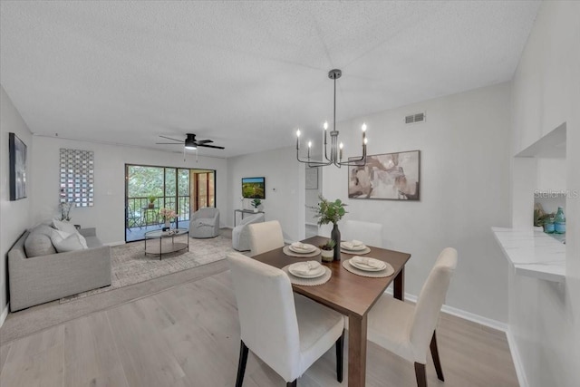 2681 Sabal Springs Cir Unit 204, Clearwater, FL 33761 - dining space featuring a textured ceiling, light wood finished floors, a chandelier, and ceiling fan
