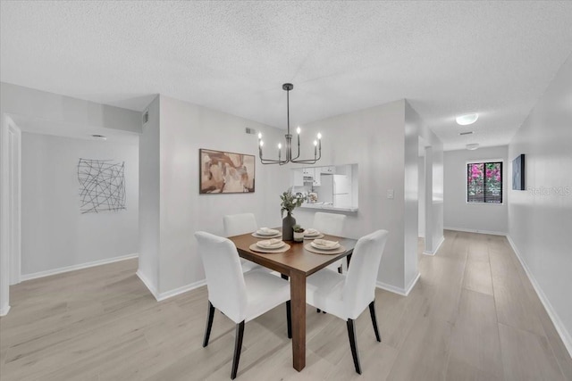 2681 Sabal Springs Cir Unit 204, Clearwater, FL 33761 - dining space with a chandelier, a textured ceiling, and light wood-type flooring