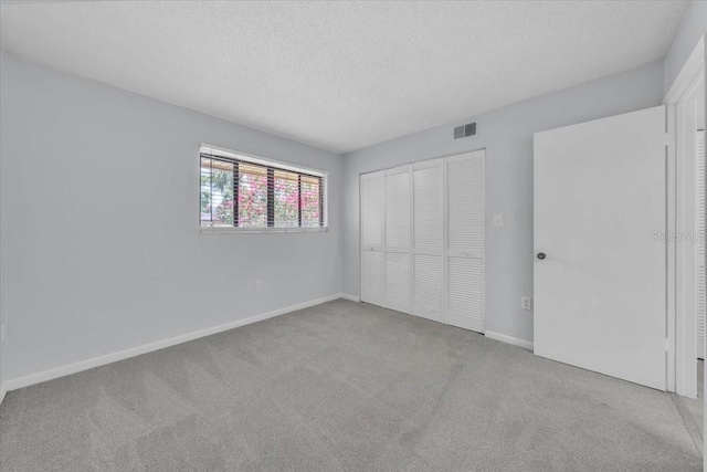 2681 Sabal Springs Cir Unit 204, Clearwater, FL 33761 - unfurnished bedroom with carpet, a closet, and a textured ceiling