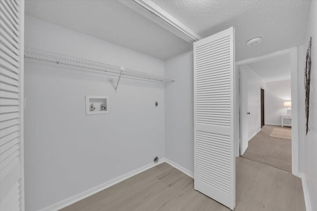 2681 Sabal Springs Cir Unit 204, Clearwater, FL 33761 - laundry room with light wood-style flooring, electric dryer hookup, hookup for a washing machine, and a textured ceiling