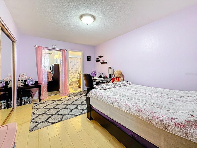 5870 38th Ave N Unit 44, Saint Petersburg, FL 33710 - bedroom featuring a textured ceiling, wood finished floors, and ensuite bathroom