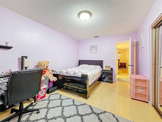 5870 38th Ave N Unit 44, Saint Petersburg, FL 33710 - bedroom with light wood-style flooring and a textured ceiling
