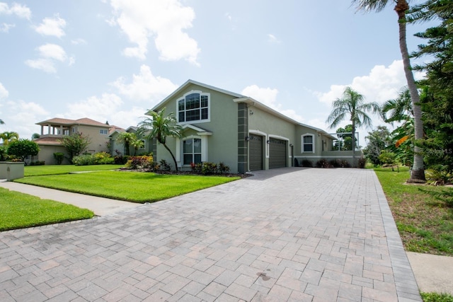916 Bunker View Dr, Apollo Beach, FL 33572 - mediterranean / spanish home featuring stucco siding, decorative driveway, a garage, and a front yard